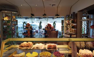 Eine gemütliche Bäckerei mit einer Auswahl an süßen und herzhaften Backwaren. Im Hintergrund sieht man Tische und Stühle für Gäste. | © Kleinwalsertal Tourismus | N. Lughammer