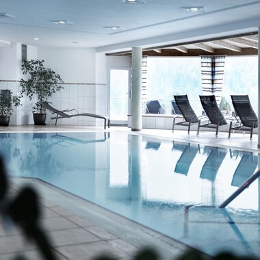 Ein heller Innenpool mit Liegen und Pflanzen. Der Raum ist modern und einladend gestaltet. | © Hotel Birkenhöhe