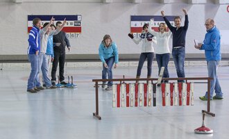 A group of people is celebrating on a curling rink. They display joy and enthusiasm while playing. | © Sportstätten Oberstdorf | Marc Vogel