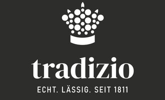 Ein einfaches Logo von tradizio mit einer Krone aus Punkten. Der Slogan lautet: "Echt. Lässig. Seit 1811." | © tradizio_logo_