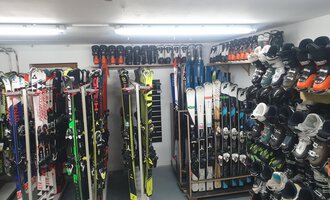 Ein Raum mit mehreren Skiern und Skischuhen, ordentlich gestapelt auf Regalen. Die Beleuchtung ist hell und es sieht nach einem Ski-Verleih aus. | © IFA Hotel Alpenrose