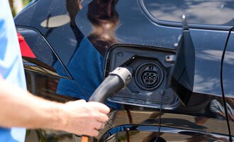 An electric car is being charged. A charging cable is plugged into the charging port. | © Kleinwalsertal Tourismus | Oliver Farys