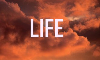 Ein farbenfroher Sonnenuntergang mit Wolken in warmen Tönen. Im Vordergrund steht das Wort "LIFE" in großen Buchstaben.