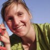 Young woman smiling, wearing sunglasses on her head and a green shirt on a sunny day. | © Kleinwalsertal Tourismus eGen