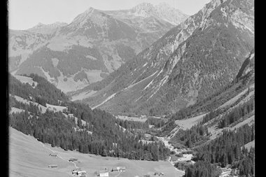 Beautiful mountain landscape in the valley with small farms, surrounded by high peaks, in a historic black-and-white photo. | © Kleinwalsertal Tourismus eGen • Karl Max Kessler Archiv