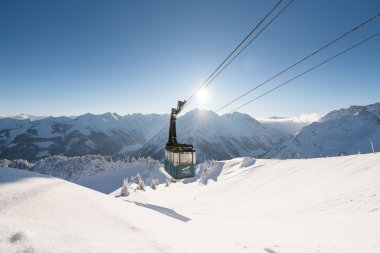 Gondelbahn im Wintertraum mit verschneiten Bergen und klarer Himmelssonne im Hintergrund. | © Oberstdorf · Kleinwalsertal Bergbahnen