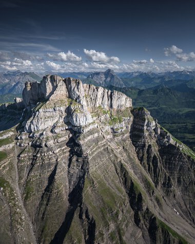 Berglandschaft mit steilen Felsen und grünen Hängen unter einem bewölkten Himmel. | © Kleinwalsertal Tourismus eGen • Fotograf: Robert Niederwolfsgruber